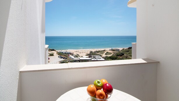 Ein Balkon mit Blick auf den Strand und einer Obstschale.