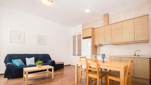 Una sala de estar moderna con un sofá, una mesa de centro y una mesa de comedor con sillas.