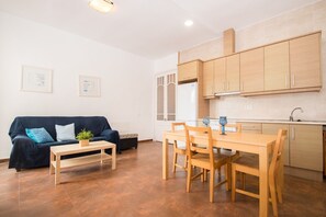 Una sala de estar moderna con un sofá, una mesa de centro y una mesa de comedor con sillas.