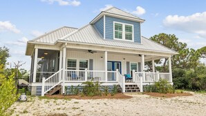 A coastal house with a porch, a small staircase, and a clear sky. - Beach House Near Pool and Boardwalk (Cape San Blas)