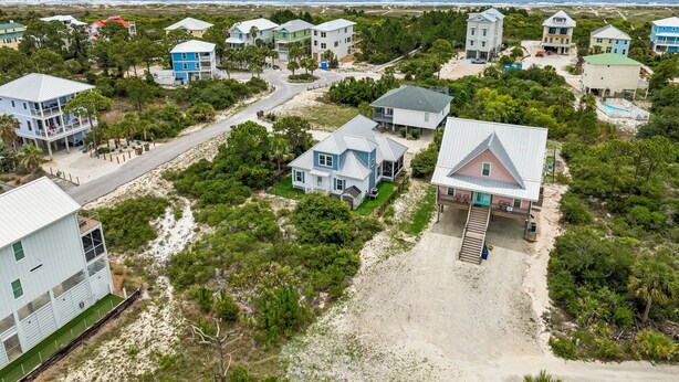 An aerial view of a coastal residential area with houses, a beach, and a clear view of the ocean. - Beach House Near Pool and Boardwalk (Cape San Blas)