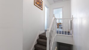 A staircase with white railings and a carpeted landing. - Platform Stadium Apartment (Hull)