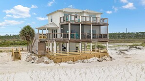 A two-story beach house with a wooden deck, a covered patio, and a view of the beach. - Gulf Front | Outdoor Shower | Dogs Allowed (Port St. Joe)