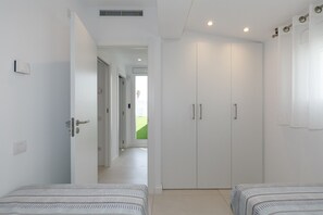 A bedroom with two beds, a wardrobe, and a door leading to a hallway. - VILLA LOS DADOS: 4 bedrooms, private pool, jacuzzi, and barbecue (Miami Playa)