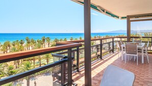 A balcony with a view of the ocean, a table with chairs, and a railing. - Spectacular Apartment in the heart of Paseo Jaime I - UHC ANAGABU (Only families) (Salou)
