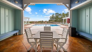An outdoor patio with a pool, benches, and a view of the pool area.