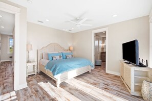 A bedroom with a bed, bedside tables, a ceiling fan, and a television. - Bay Front Escape w/ Dock and Gulf Views (Port St Joe)