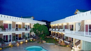 Un hôtel doté d’une piscine, de plusieurs balcons et d  ’une cour bien éclairée.