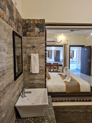 A bathroom with a sink, mirror, and towel rack. - Vow Resorts And Spa (Kaladhungi)