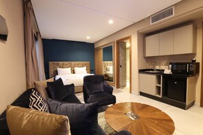 A hotel room with a bed, a sofa, a coffee table, and a kitchenette. - ADDRESS Hôtel Casablanca (Casablanca)
