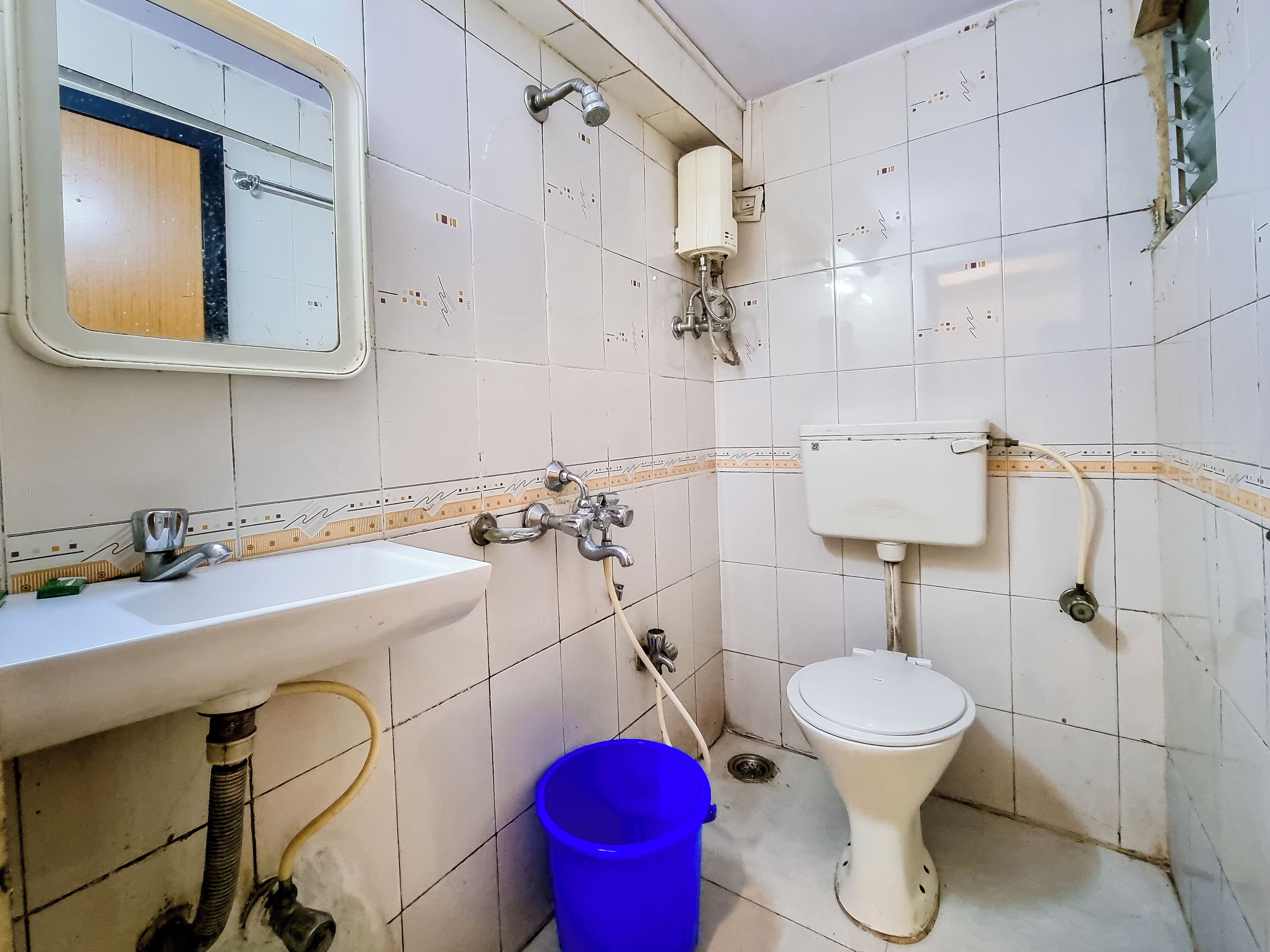 A small bathroom with a sink, toilet, and shower.