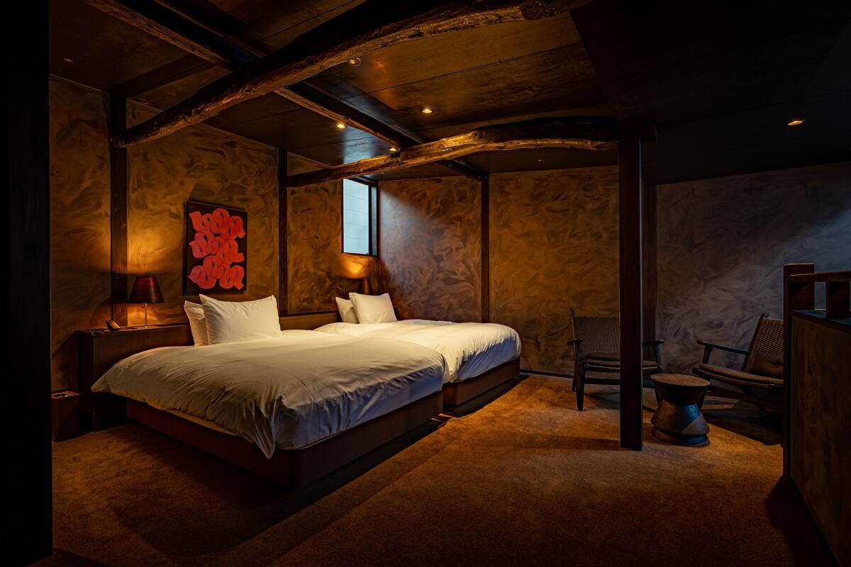 A bedroom with a large bed, two bedside tables, a chair, and a small table.