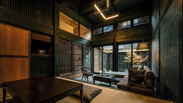 A modern interior with a wooden table, seating, and large windows. - BYAKU Narai (Shiojiri)