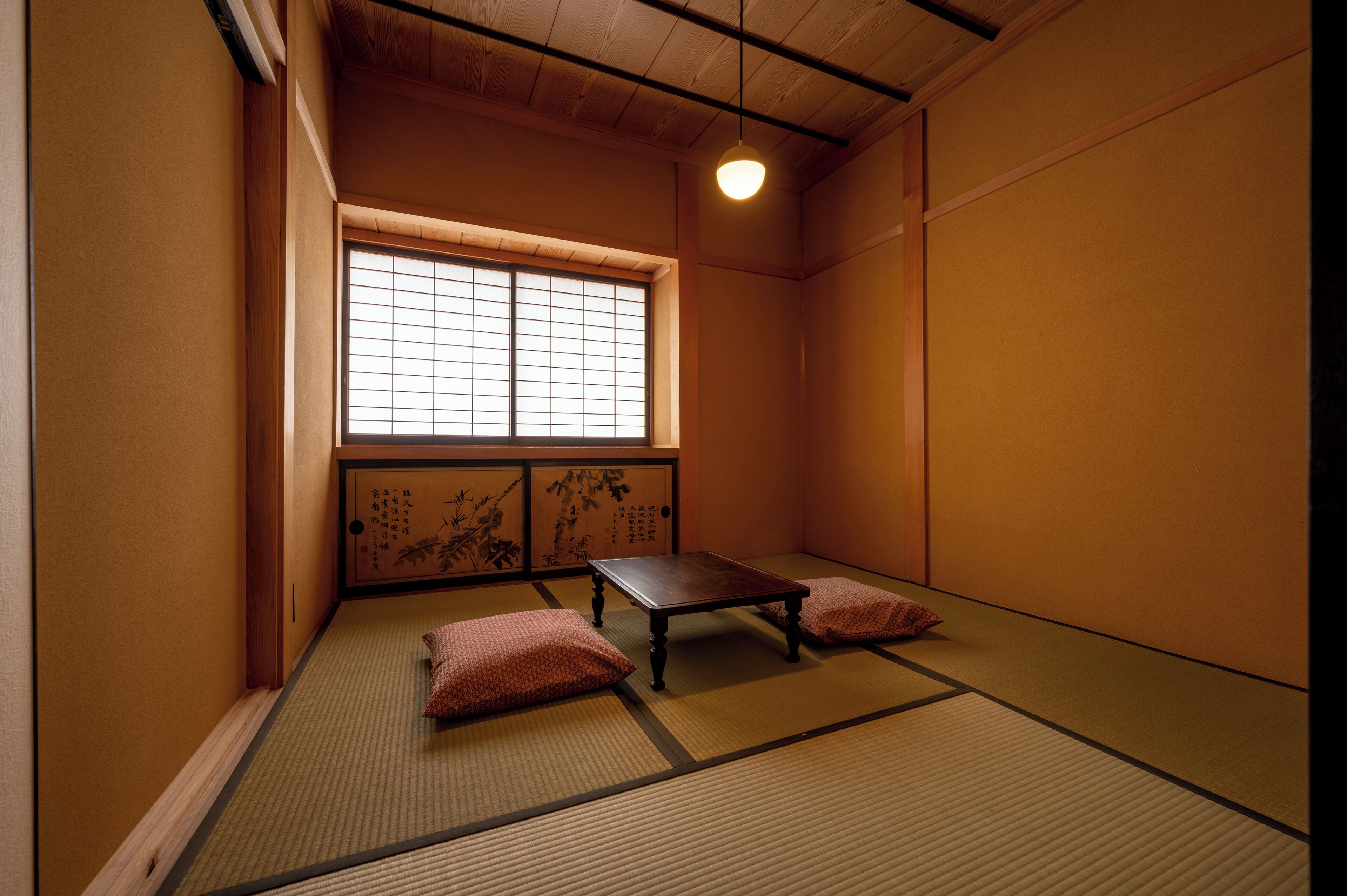 A traditional Japanese room with tatami flooring, a low wooden table, and shoji screens.
