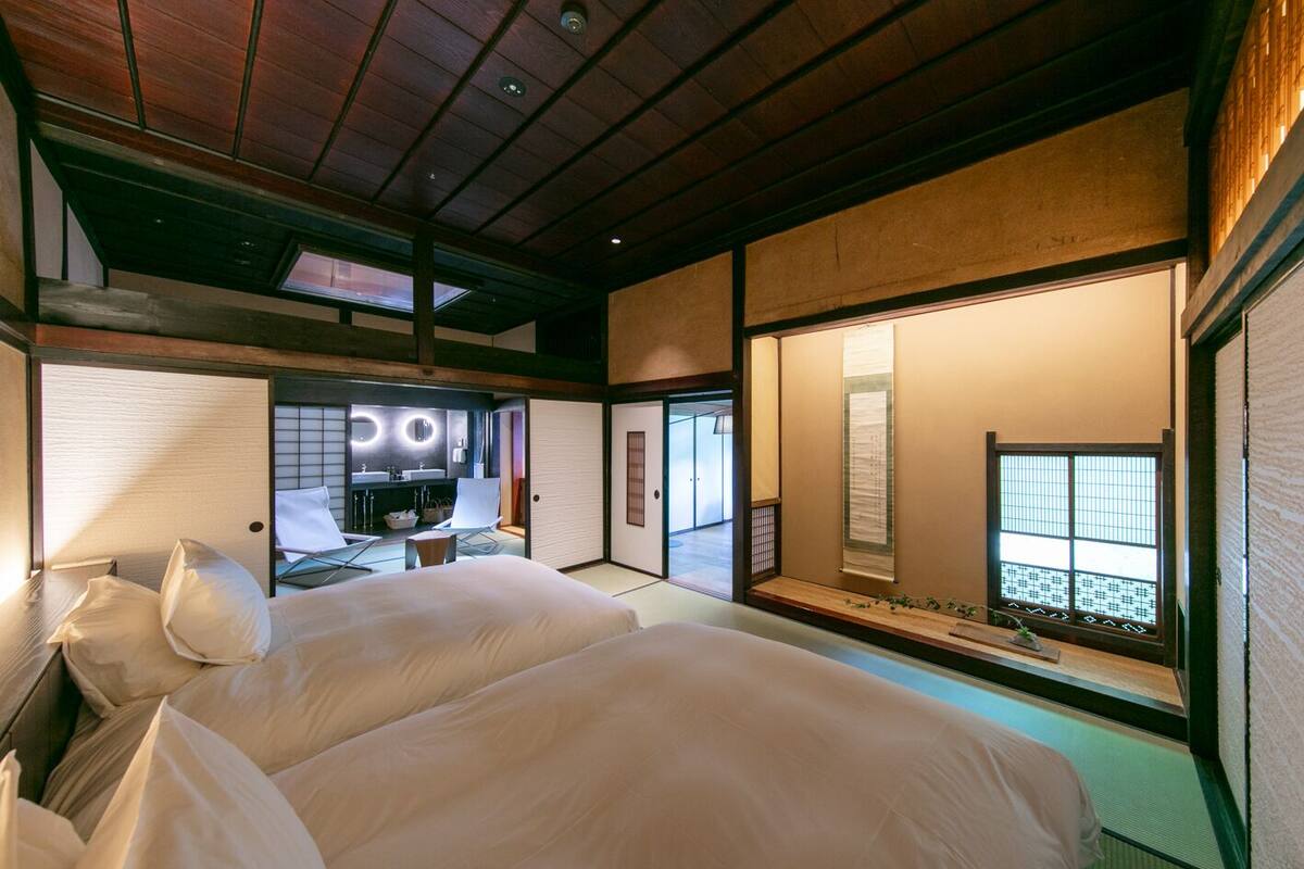 A traditional Japanese-style room with tatami flooring, a low ceiling, and sliding doors.