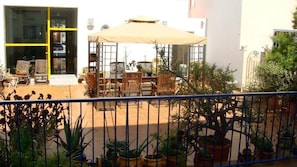Eine Terrassengruppe im Freien mit Esstisch, Stühlen und Topfpflanzen.