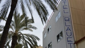 Un hotel llamado "HOTEL BLAUET" con una fachada moderna, varios ventanales y una entrada visible.