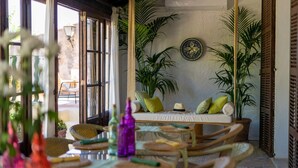 A cozy room with wicker furniture, a sofa with cushions, and potted plants. - León de Sineu - Ten Bedroom Villa, Sleeps 21 (Sineu)