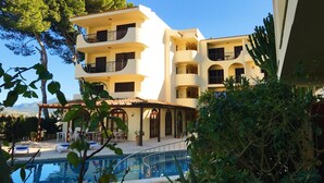 A multi-story hotel with balconies, a swimming pool, and lush greenery. - Casa vida 1 bedroom · Family Friendly Apartment ¨Casa Vida¨ 1 Bedroom (Santa Ponça)