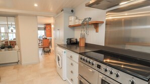 Una cucina moderna con elettrodomestici in acciaio inossidabile, forno integrato e lavatrice.