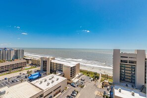 Ein Küstenhotel mit mehreren Gebäuden, einem Parkplatz und Blick auf den Strand und den Ozean.
