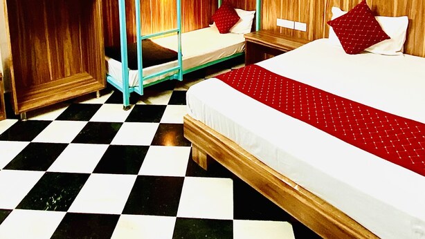 Een kamer met stapelbedden, een geruit vloertje en houten lambrisering.