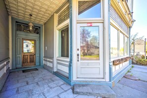 Een gebouw met een voordeur, een raam en een veranda.