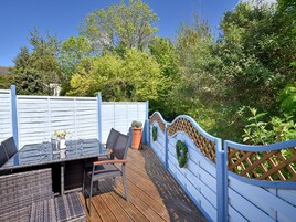 Un patio al aire libre con una mesa lista para comer, una silla y una maceta.