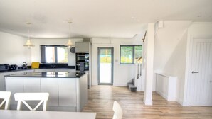 Eine moderne Küche mit einer zentralen Kochinsel, weißen Schränken und Pendelleuchten.