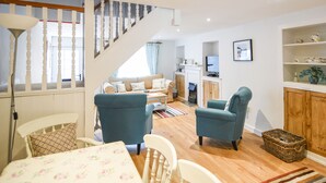 Ein modernes Wohnzimmer mit Treppe, Essbereich und Küche.
