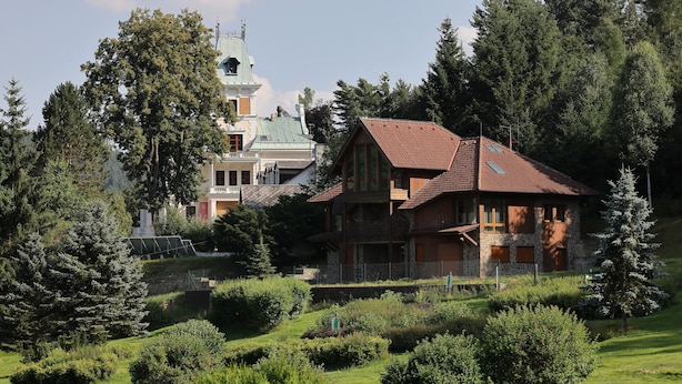 A large house with a red roof, surrounded by lush greenery and trees. - Villa Golf (Karlovy Vary)