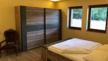 A bedroom with a bed, a chair, and a wardrobe.