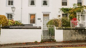 A white building with a sign reading "RAPHAEL'S COTTAGE" and a gate with a number "21".