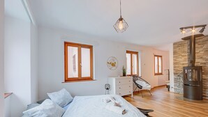 Een moderne slaapkamer met een bed, een dressoir, een spiegel en een stenen muur.