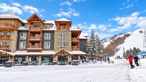 A multi-story lodge with a stone facade and wooden balconies, located in a snowy mountainous area. - Newly Renovated Ski-In Studio: Hot Tubs, Pool, Tennis, Walk or Ski to Slopes (Blue Mountains)