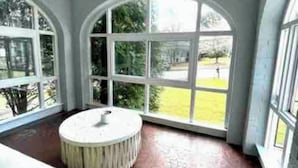 A room with a large arched window, a ceiling fan, and a round table. - Beautiful Bright 6 bedroom home in the heart of Buckhead (Atlanta)