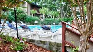 A pool area with lounge chairs and a wooden deck. - Elegant Condo in the Heart of Northern Myrtle Beach close to beach (Myrtle Beach)