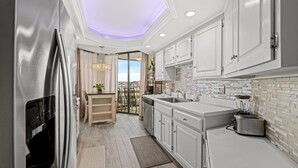 A modern kitchen with white cabinetry, a stainless steel refrigerator, a built-in oven, a sink, and a toaster. - Ocean View, recently updated, 24 hour security + Free Attraction Tickets! (Myrtle Beach)