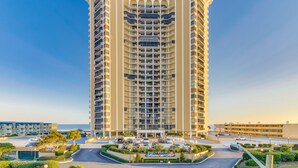 A tall, multi-story hotel with a central courtyard and a view of the sea. - Ocean View, recently updated, 24 hour security + Free Attraction Tickets! (Myrtle Beach)