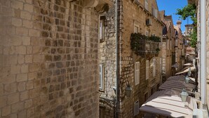 A narrow street with stone buildings, shutters, and a tiled roof. - Studio Nikol (Dubrovnik)