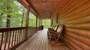 A wooden cabin with a porch, wooden benches, and a grill. - Yonah View Lodge - 2 BR Cabin w/ Spacious Decks, Hot Tub, Fire Pit, Near Helen (Cleveland)