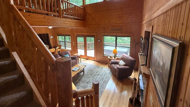 A spacious wooden cabin with a loft bedroom, a dining area, and a living room with a fireplace. - Yonah View Lodge - 2 BR Cabin w/ Spacious Decks, Hot Tub, Fire Pit, Near Helen (Cleveland)
