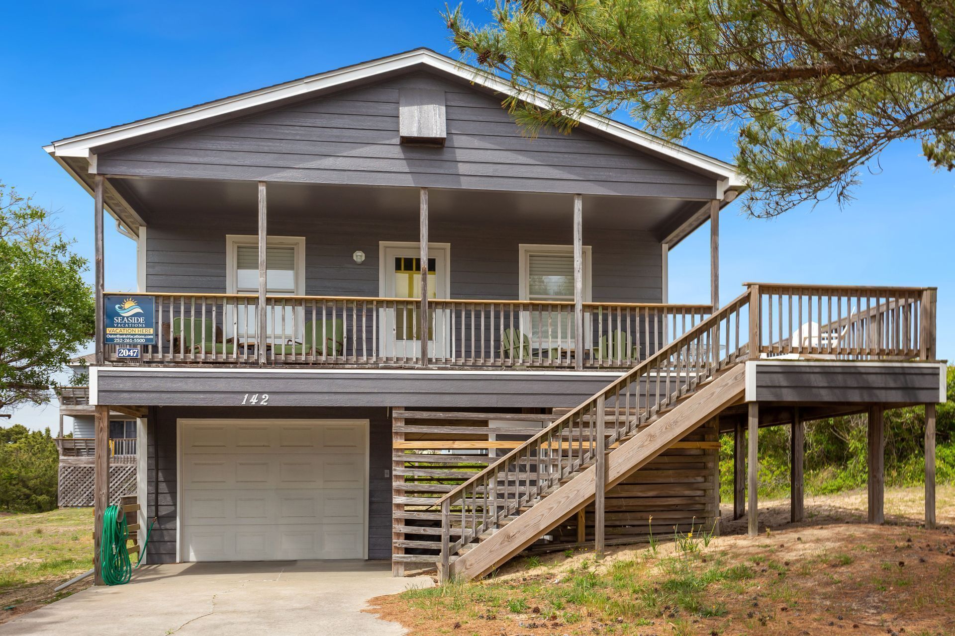 A two-story house with a covered porch, a garage, and a staircase leading to a second level.