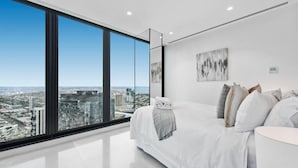 Une chambre moderne avec une grande fenêtre, un lit et une vue sur la ville.