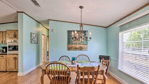 A dining room with a wooden table, chairs, and a chandelier. - Steinhatchee Home w/ Boat Parking: 1 Mi to Marina (Steinhatchee)