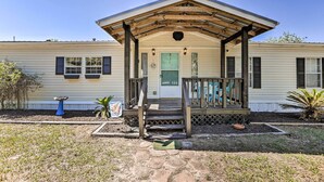 A single-story mobile home with a covered porch, a front door, and a small front yard. - Steinhatchee Home w/ Boat Parking: 1 Mi to Marina (Steinhatchee)