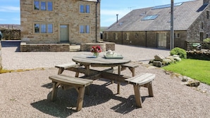 A stone building with a gravel patio and wooden benches. - Lanshaw House (Lancaster)