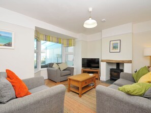 A living room with two sofas, a coffee table, a television, and a fireplace. - The Porthole (Port Isaac)