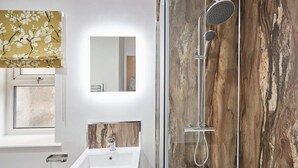 A modern bathroom with a glass-enclosed shower, a white sink, and a mirror. - Host & Stay | Studio Pod 2 (Saltburn-by-the-Sea)