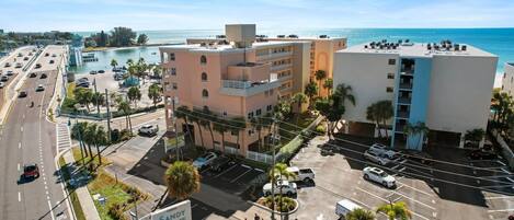 Un hotel de varios pisos con estacionamiento y vista a la playa.